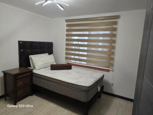 a small bedroom with a bed and a window at Casa Lago Rapel in Las Cabras