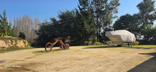 a boat is parked on the side of a dirt road at Casa Lago Rapel in Las Cabras
