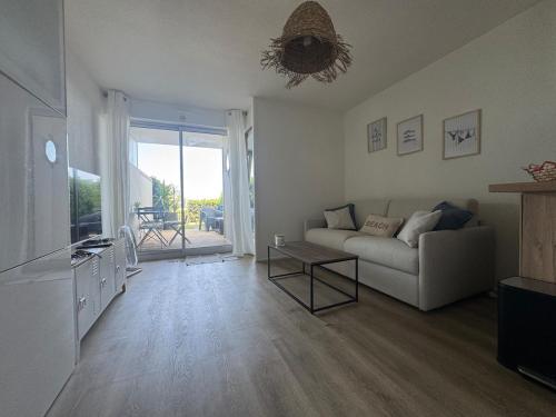 un salon avec un canapé et une table dans l'établissement Les pieds dans l'eau - accès mer, à Canet