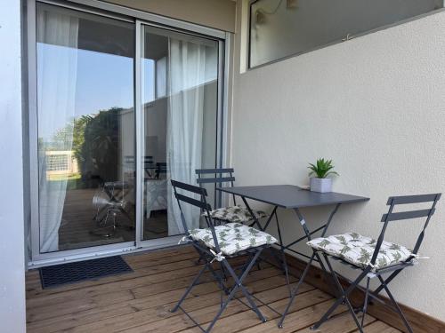 d'un balcon avec une table et des chaises. dans l'établissement Les pieds dans l'eau - accès mer, à Canet