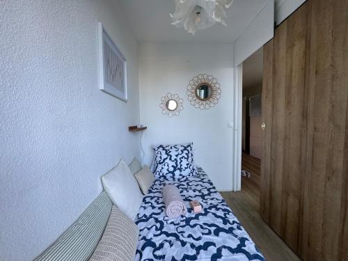 une chambre avec un lit et un miroir au mur dans l'établissement Les pieds dans l'eau - accès mer, à Canet