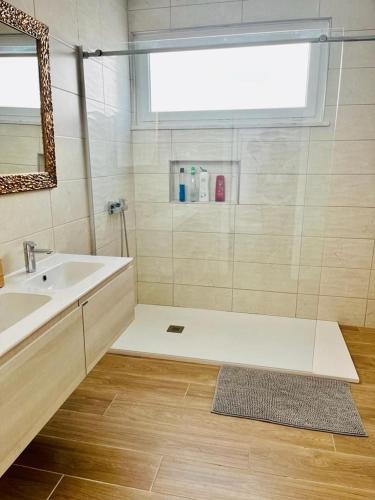 a bathroom with a sink and a shower with a mirror at Maison de Sable - Possanco in Comporta