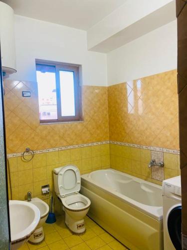 a bathroom with a toilet and a tub and a sink at Vila Brahimasi in Durrës