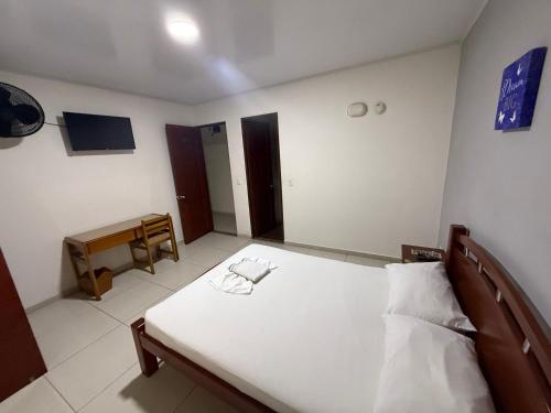 a bedroom with a bed and a piano in it at HOTEL VILLAREAL VILLAVICENCiO in Villavicencio