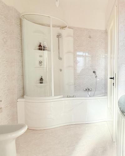 a white bathroom with a tub and a sink at Appartamento Da Elisa in Quartu SantʼElena