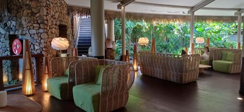 a living room with chairs and a wall of windows at Matavai View - Premium Oceanfront Suite in Arue