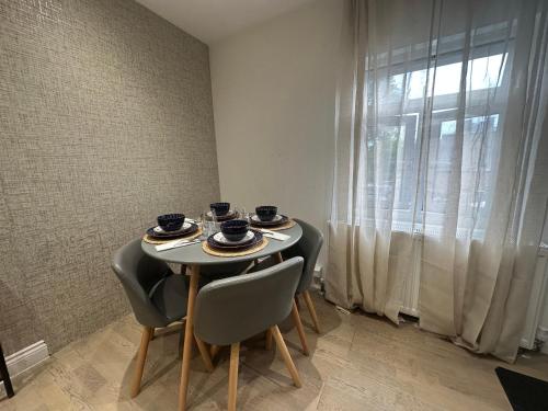 a table with four cups and chairs in a room with a window at The Hideaway Haven in Belvedere