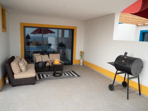 a living room with a grill and a patio at Blue Coast Villas - Villa 6 in Cidade Velha