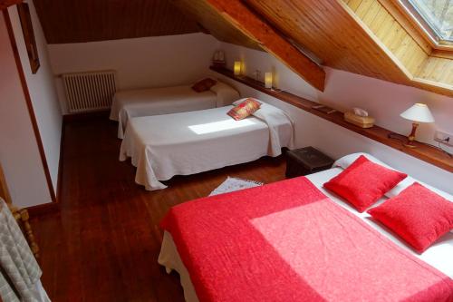 a attic room with two beds and a window at Días de Luna in Sena de Luna