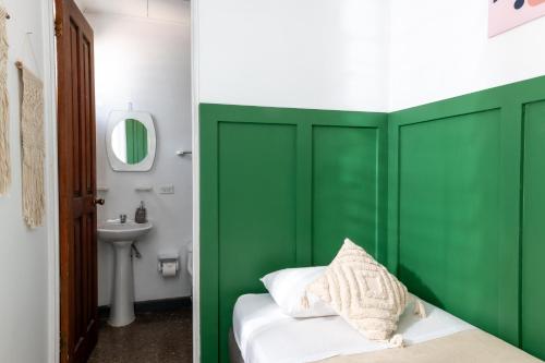 a green headboard in a bathroom with a sink at Capital Hostel de Ciudad in San José