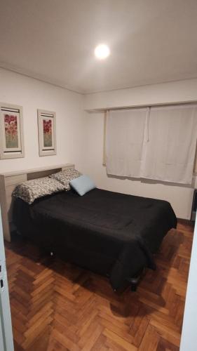 a bedroom with a black bed in a room at Departamento Céntrico con Balcón a la calle in Mar del Plata