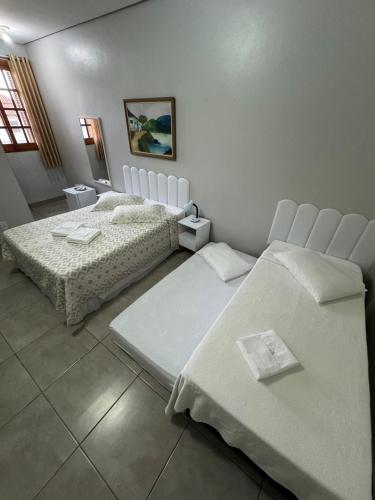a room with two beds in a room at Hotel Brasil Real in Guaíba