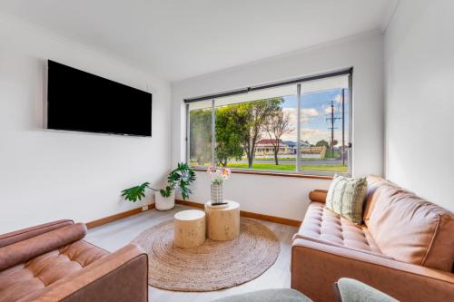 a living room with a couch and a tv at The sweet and spicy retreat in Mount Gambier