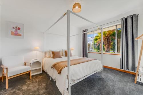 a bedroom with a canopy bed and a window at The sweet and spicy retreat in Mount Gambier