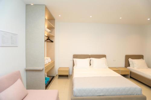 a bedroom with two beds and a couch at Divos Apartments in Vlorë