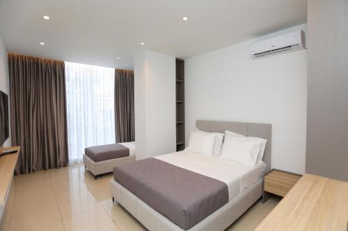 a hotel room with a bed and a television at Divos Apartments in Vlorë