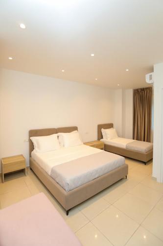 a large bedroom with two beds and a couch at Divos Apartments in Vlorë