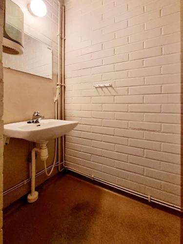 a bathroom with a sink and a white brick wall at Raasepori camping in Raseborg