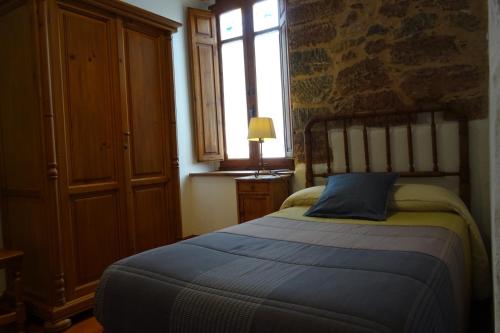 a bedroom with a bed in a room with a window at Días de Luna in Sena de Luna