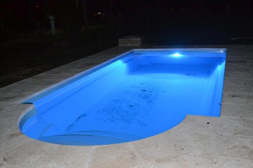 a blue swimming pool at night at Cabañas La Mercedes-Cabaña 1 in Tupungato
