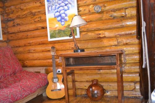 a living room with a guitar and a couch at Cabañas La Mercedes-Cabaña 1 in Tupungato