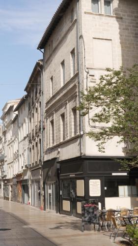 a building on the side of a street with benches at Maison Jacob - Hyper centre - Maison historique - Air conditioning - Wifi in Avignon