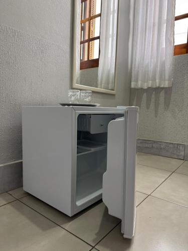 a microwave sitting on a floor with a mirror at Hotel Brasil Real in Guaíba