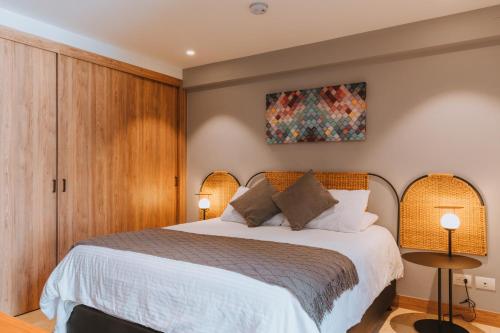 une chambre avec un grand lit avec deux lampes dans l'établissement Edificio Boutique Alori 15-3, à Medellín