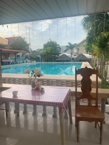 Una mesa y una silla en una habitación con piscina. en Midpoint, en Mandaue