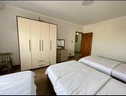 a bedroom with two beds and a large cabinet at Family apartment at The Nile maadi in Cairo