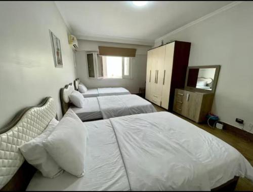 a bedroom with two beds and a mirror at Family apartment at The Nile maadi in Cairo