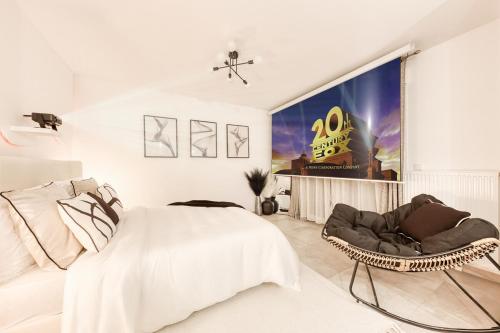 a white bedroom with a bed and a chair at Studio Chic avec Cinéma Privé À 15 min de Disneyland et 20 min de Paris in Champs-Sur-Marne