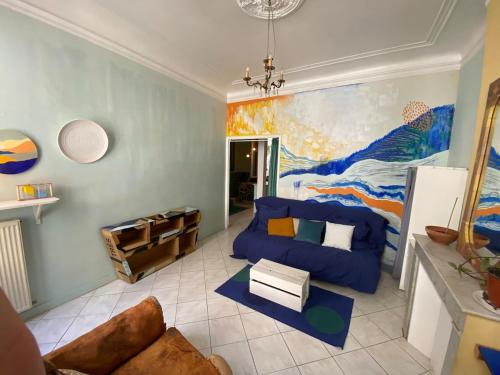 un salon avec un canapé bleu et un tableau dans l'établissement FLC Bail mobilité - Canebière-Vieux Port-terrasse - 2 bedrooms, à Marseille