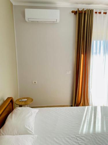 a bedroom with a white bed and a window at EasySleep City Center in Divjakë