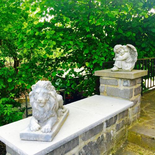 two statues of lions sitting on a stone wall at B&B Le Notaire in Bomal