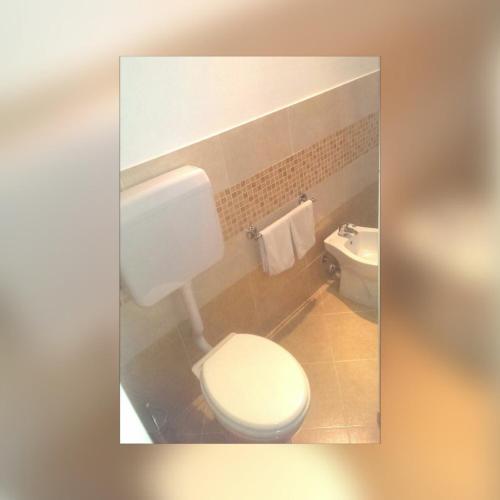 a bathroom with a white toilet and a sink at I Faraglioni Comfort Rooms in Terrasini