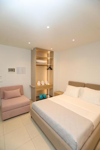 a bedroom with a large bed and a chair at Divos Apartments in Vlorë