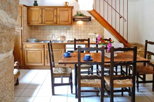 a kitchen with a wooden table with chairs and a sink at Charming stone house with shared pool, Chambonas in Chambonas