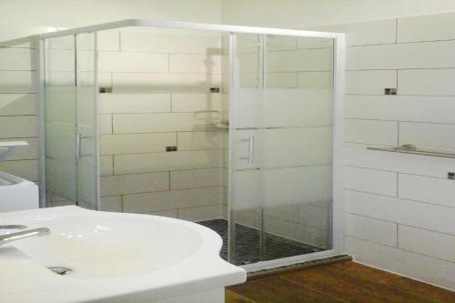 a bathroom with a glass shower with a sink at Charming stone house with shared pool, Chambonas in Chambonas