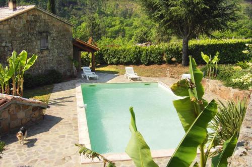 a swimming pool in a yard with two chairs at Charming stone house with shared pool, Chambonas in Chambonas