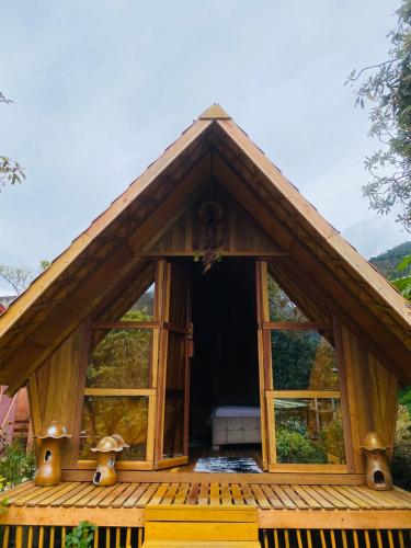 a small wooden house with large windows on a deck at Gemma Eco-Glamping in Baños