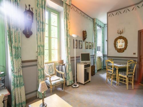 un salon avec une table, des chaises et des fenêtres dans l'établissement Cozy Apartment with Swimming Pool, Terrace, Garden, Parking, à Montbrun-les-Bains