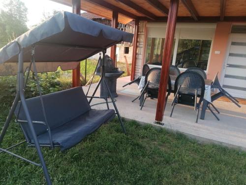 a chair under an umbrella on a patio at Vila Ana Marija in Berovo