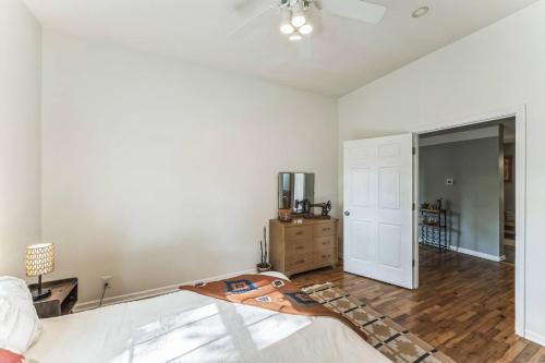 a bedroom with white walls and a bed with a wooden floor at Old School Charm | Sleeps 6 in Buchanan