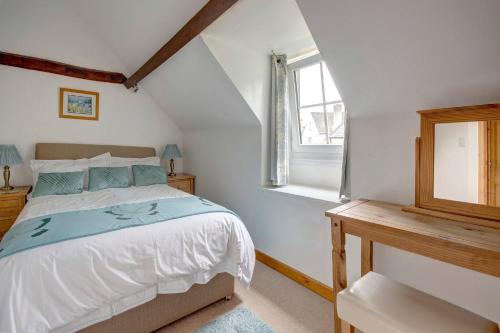 a bedroom with a bed and a window at Stunning Cotswold Cottage Nr Country & River Walks in North Cerney