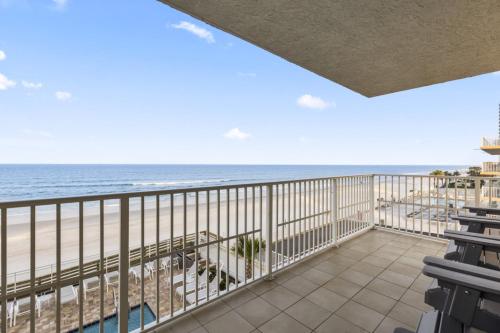 a balcony with a view of the beach at A Wave From it All Oceanfront Pool Condo in Daytona Beach