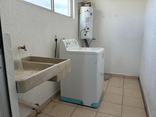 a bathroom with a sink and a washing machine at Extraordinario departamento in Guadalajara