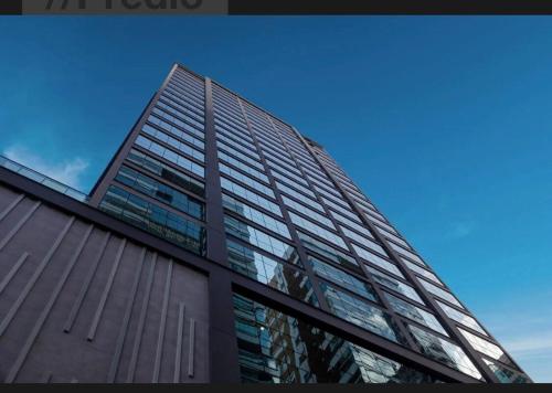 a tall building with glass windows on the side of it at Para pessoas exigentes Para pessoas exigentes in Itapema