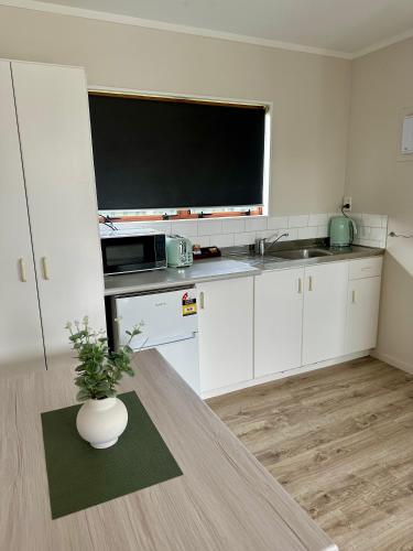 a kitchen with a large flat screen tv on a counter at Bay Lodge Motel in Tauranga