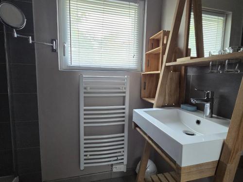 une salle de bain avec un lavabo blanc et une fenêtre dans l'établissement Maison bord de mer pour 4 pers., animaux acceptés, WiFi, parking - FR-1-364-175, à Saint-Brévin-les-Pins